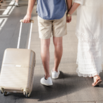 man and woman walking with suitcase